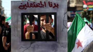 A protester seen with a portrait of cell bars during a
